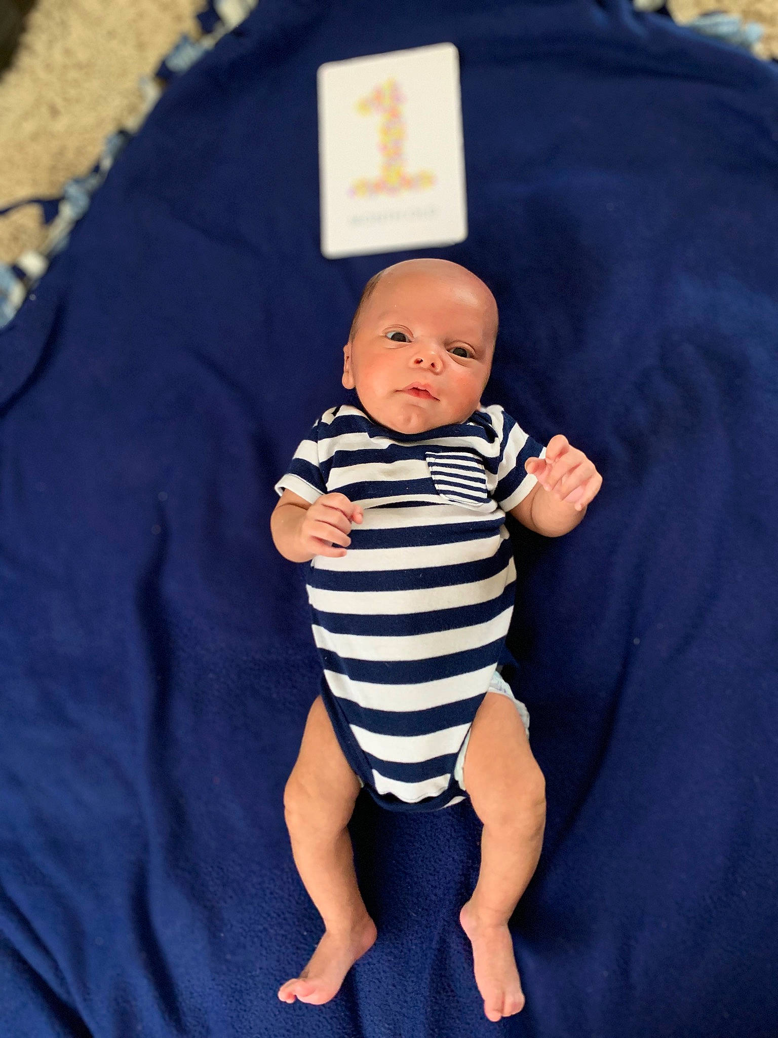 Kylan is registered to the contest to win money with this photo: baby, baby_products, baby_toddler_clothing, button, child, collar, day_dress, electric_blue, gesture, hand, happy, human_body, nail, one_piece_garment, pattern, person, purple, sitting, sleeve, thumb