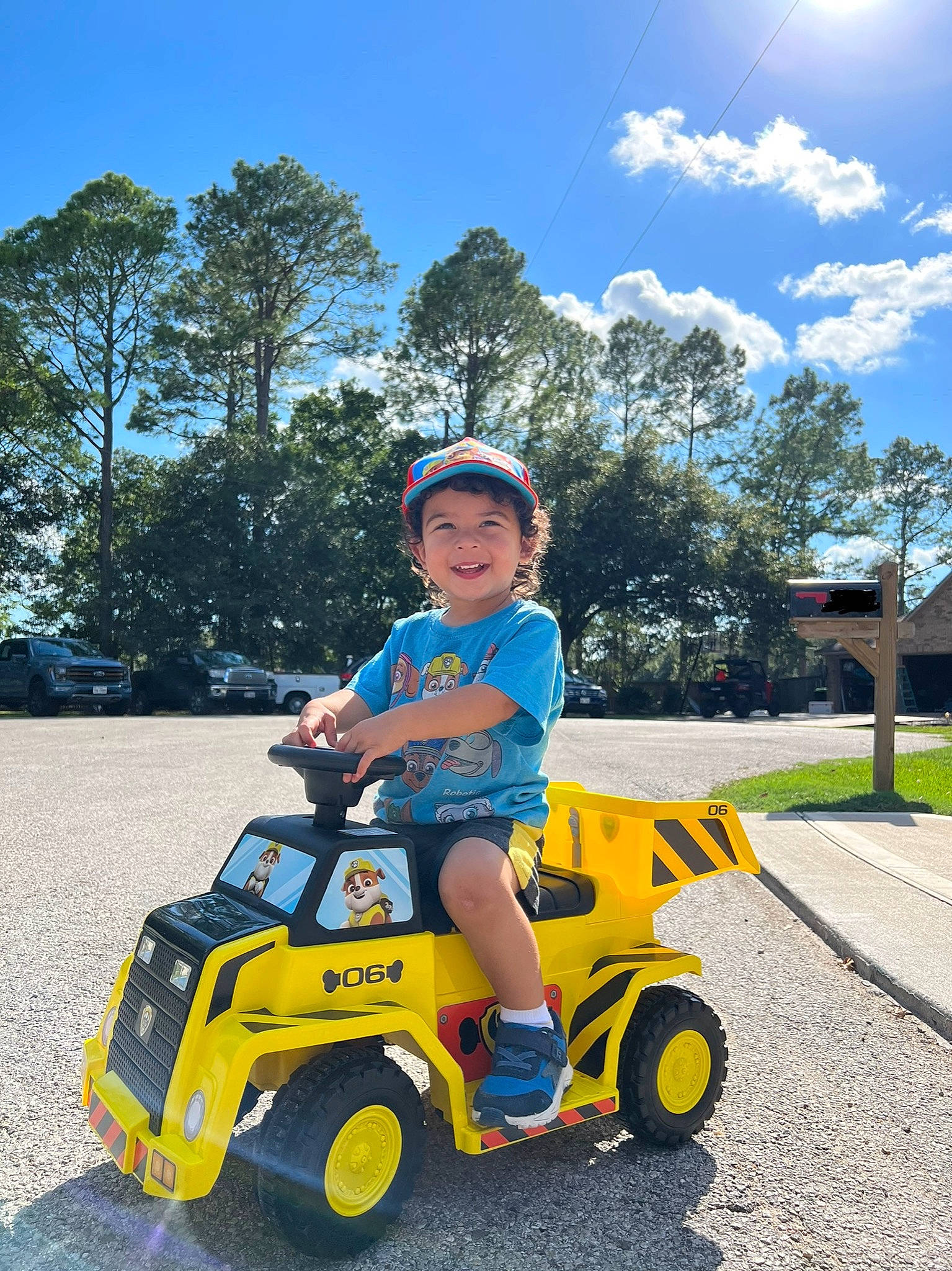 Ander is registered to the contest to win money with this photo: asphalt, automotive_tire, automotive_wheel_system, cloud, fun, grass, headwear, helmet, joy, motor_vehicle, person, plant, recreation, riding_toy, rolling, shorts, sky, tire, toddler, tread