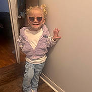 Tatym is registered to the contest to win money with this photo: casual_clothing, child, cute, fashion, girl, hair_tied, happy, heart_shaped, indoor, jacket, jeans, lavender, person, pose, smile, sneakers, standing, sunglasses, wall, wooden_floor