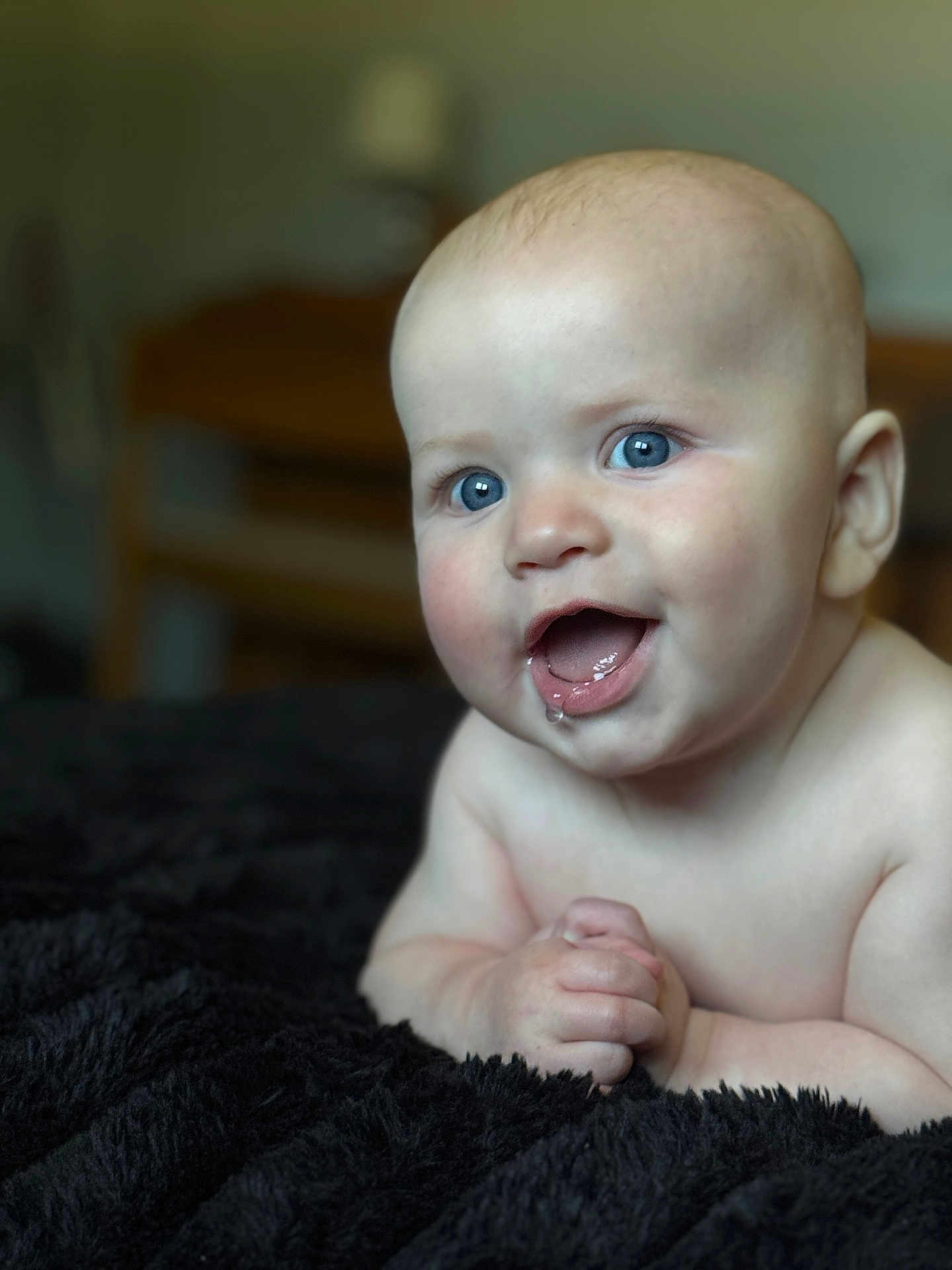 Bryson is registered to the contest to win money with this photo: baby, infant, blue_eyes, drool, hands, smiling, portrait, closeup, skin, cute, lying_down, black_blanket, soft_light, indoors, happy, child, human, face, expression, young
