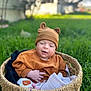 baby, infant, basket, hat, bear_hat, grass, outdoor, lawn, blanket, cozy, smiling, portrait, closeup, bokeh, blurred_background, cute, clothing, hand, feet, person