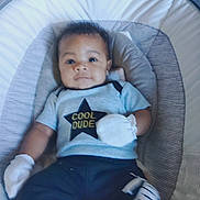 Amani is registered to the contest to win money with this photo: baby, infant, child, clothing, mittens, pants, striped, cushion, baby_seat, face, eyes, cute, comfortable, indoor, portrait, relaxing, young, person, apparel, cool_dude