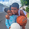 child, children, boy, girl, smiling, basketball, volleyball, sports, outdoor, street, happy, play, summer, casual_clothing, tree, sky, clouds, house, neighborhood, friendship