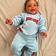 Ayden participe au concours pour gagner de l'argent avec cette photo : baby, bed_sheet, blue_clothing, casual_clothing, child, curly_hair, cute, feet, hands, happy, indoor, infant, lying_down, mickey_mouse, person, playful, portrait, smiling, toddler, young_child