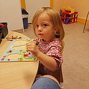 Santiana a rejoint le concours — aidez-le/la à gagner de superbes lots ! child, toddler, puzzle, table, toy, indoor, blonde_hair, short_hair, concentration, person, clothing, furniture, floor, chair, educational_toy, colorful, playroom, casual, young_child, curious