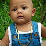 Kiel is registered to the contest to win money with this photo: baby, child, denim_overalls, gold_necklace, portrait, outdoor, greenery, curious, face, skin, eyes, cute, young, person, head, expression, fashion, nature, bench, summer