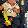 baby, infant, car_seat, smiling, blue_shoes, plush_toy, white_shirt, sitting, happy, child, toy, footwear, indoor, clothing, cute, face, expression, seatbelt, accessory, head_support