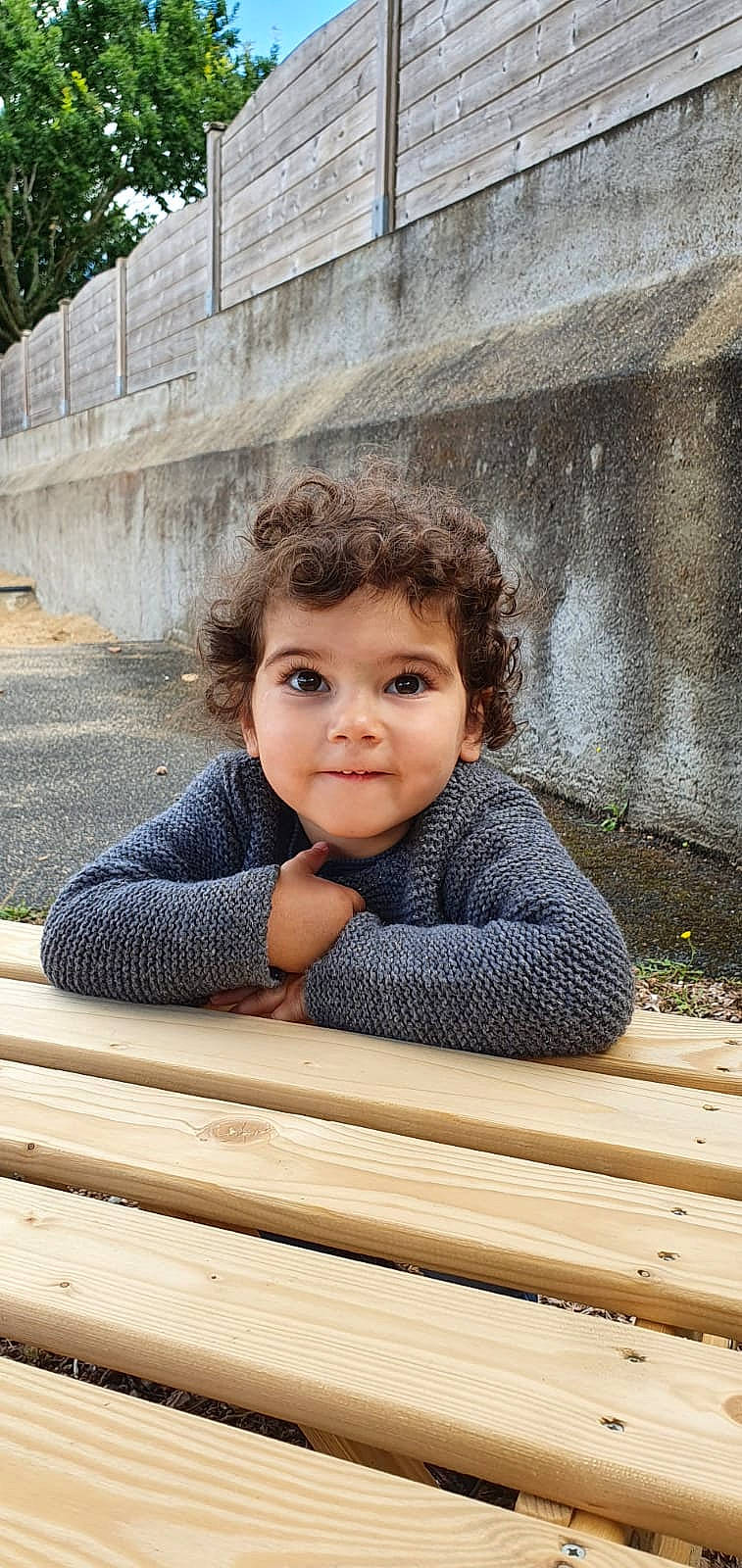 Elyna a rejoint le concours — aidez-le/la à gagner de superbes lots ! baby_toddler_clothing, cheek, chin, eye, floor, flooring, hair, hairstyle, happy, hardwood, leisure, outerwear, person, skin, smile, toddler, tree, vertebrate, wall, window