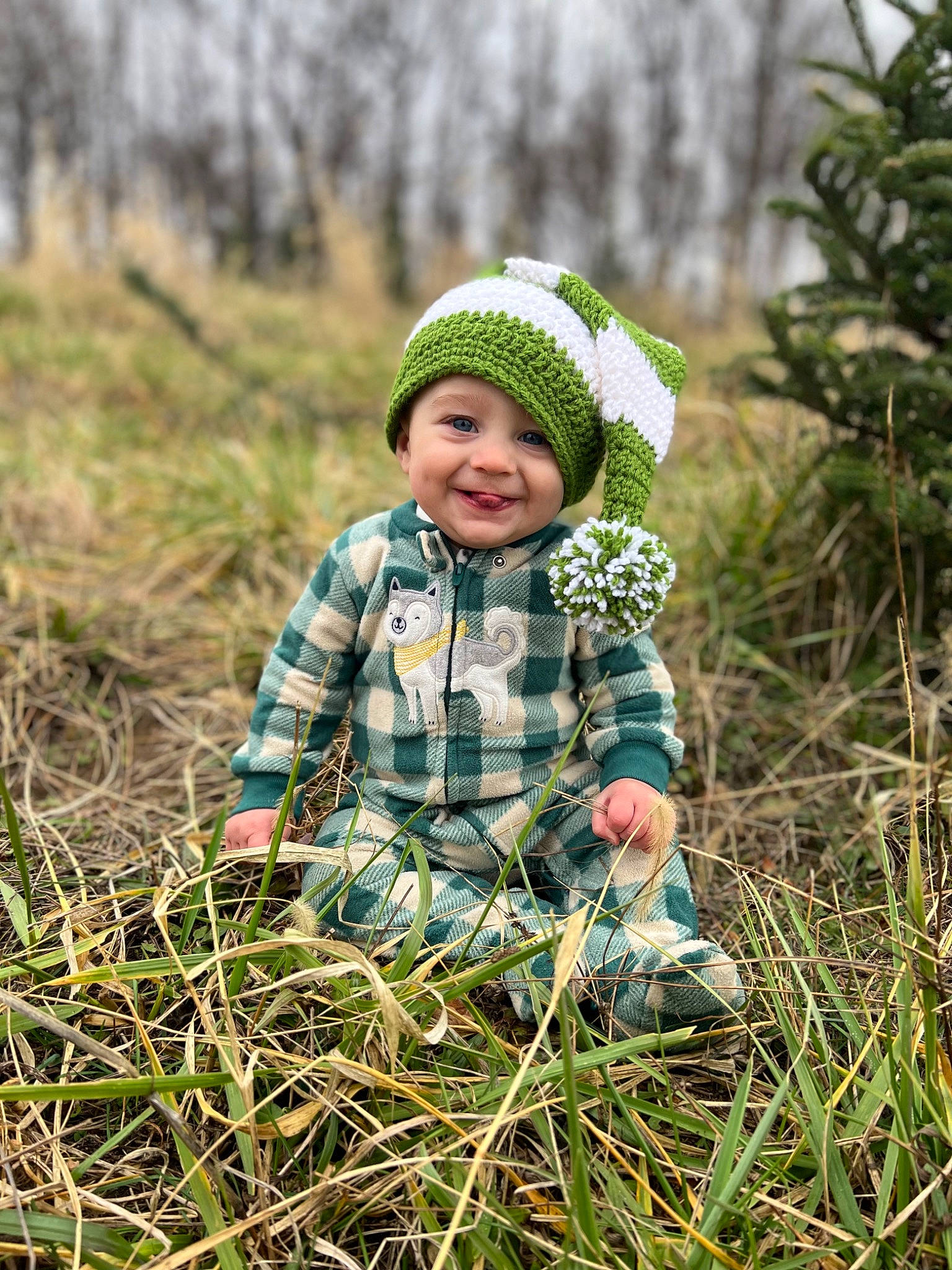 Krew is registered to the contest to win money with this photo: baby, baby_toddler_clothing, cap, child, eye, grass, grassland, hand, happy, headwear, jacket, joy, landscape, pattern, people_in_nature, person, plant, prairie, smile, toddler