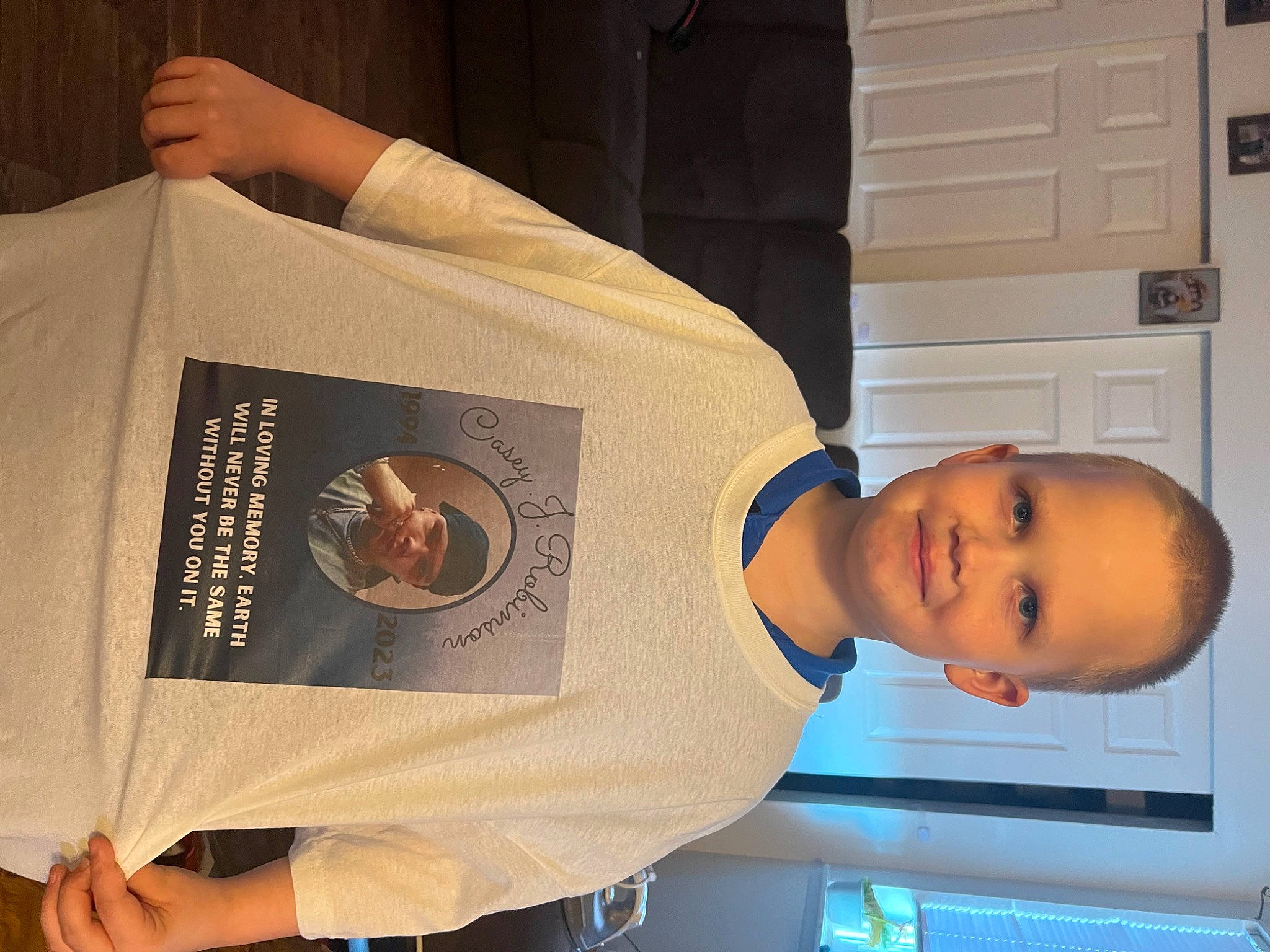 Dalton is registered to the contest to win money with this photo: baby_toddler_clothing, cabinetry, child, chin, dress_shirt, elbow, font, hat, headwear, joy, person, publication, room, sleeve, smile, t_shirt, toddler, white, wrist