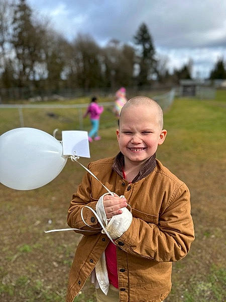 Dalton is registered to the contest to win money with this photo: balloon, child, cloud, event, fun, grass, grassland, happy, joy, landscape, leisure, people_in_nature, person, prairie, recreation, sitting, sky, smile, soil, toddler