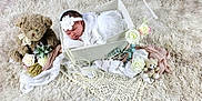 Flora participe au concours pour gagner de l'argent avec cette photo : baby, newborn, sleeping, basket, headband, flower, teddy_bear, plush_toy, blanket, rug, lace, pearls, props, portrait, soft_texture, cozy, decorative_flowers, white_theme, studio_shot, cute