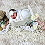 baby, newborn, sleeping, basket, headband, flower, teddy_bear, plush_toy, blanket, rug, lace, pearls, props, portrait, soft_texture, cozy, decorative_flowers, white_theme, studio_shot, cute
