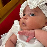 Autumn is registered to the contest to win money with this photo: baby, infant, white_dress, lace, pearls, closeup, chubby_cheeks, hand, cute, portrait, indoors, curious, gaze, soft_skin, headwear, bow, celebration, child, newborn, pink_skin