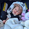 Hadley is registered to the contest to win money with this photo: baby, infant, child, smiling, car_seat, seatbelt, headband, bow, blanket, plush_toy, toy, portrait, close_up, sitting, indoors, transportation,  안전, patterned_fabric, happy, face