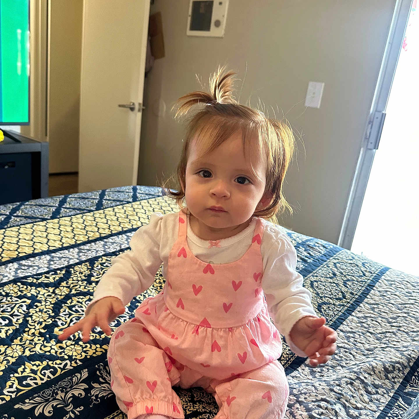 Ivanna is registered to the contest to win money with this photo: baby, bed, blanket, child, comfort, curious, door, face, hair, heart_pattern, indoor, light, person, pink_clothing, portrait, room, sitting, socks, toddler, window