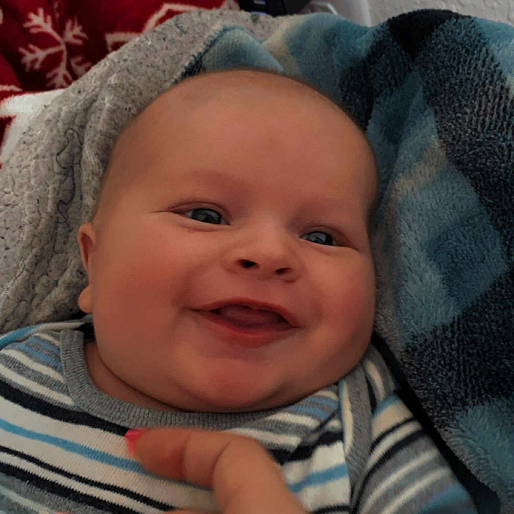 Michael is registered to the contest to win money with this photo: baby, blanket, bodypart, bonnet, clothing, couch, face, finger, furniture, hand, happy, hat, head, homedecor, knitwear, newborn, person, photography, portrait, smile