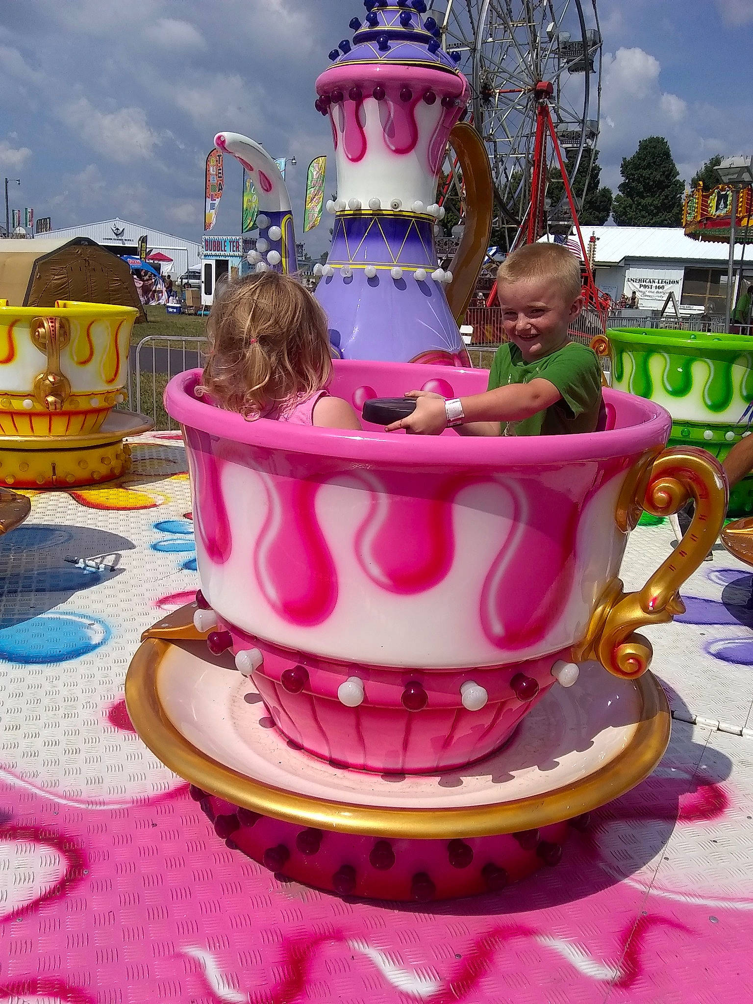Carson is registered to the contest to win money with this photo: amusement_park, amusement_ride, baked_goods, cake, cake_decorating, carousel, cup, dessert, drinkware, food, icing, joy, nonbuilding_structure, park, person, pink, recreation, serveware, sugar_paste, sweetness