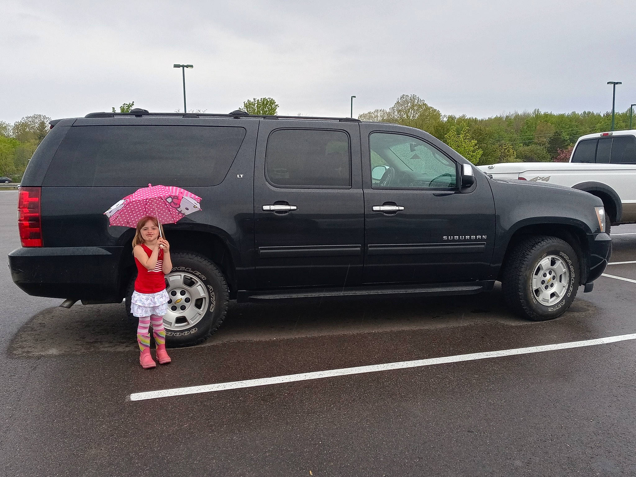 Naomi is registered to the contest to win money with this photo: alloy_wheel, asphalt, automotive_design, automotive_exterior, automotive_mirror, automotive_tire, bumper, car, cloud, fender, joy, land_vehicle, landscape, motor_vehicle, person, rim, sky, tire, tree, vehicle