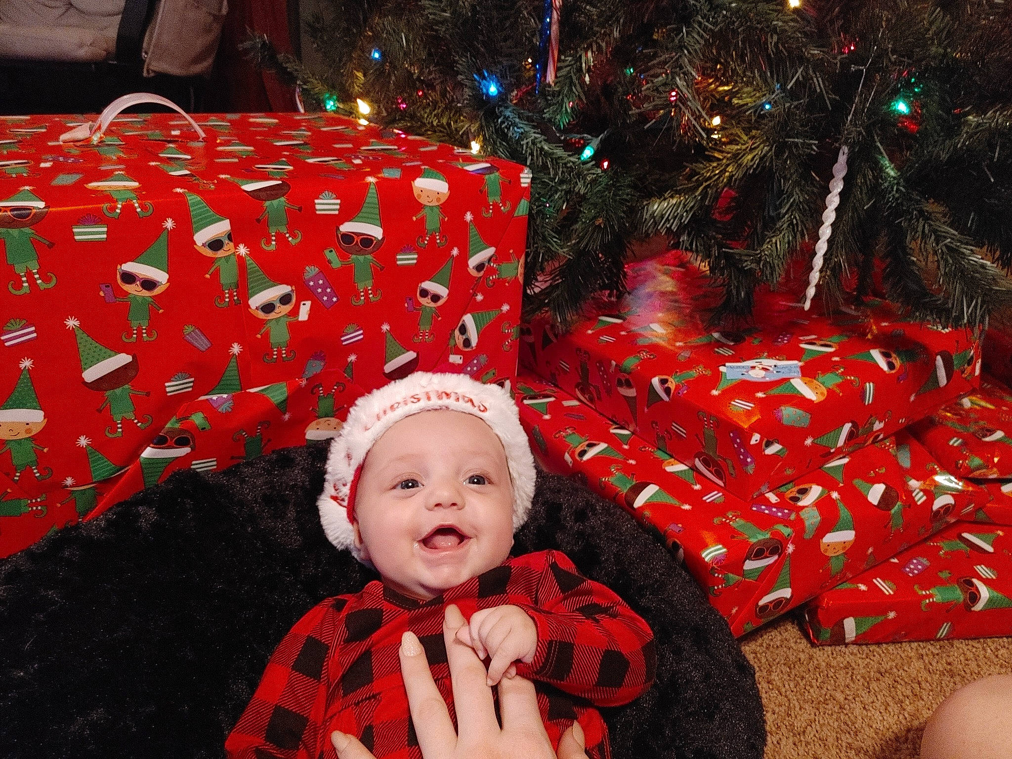 Jazlyn is registered to the contest to win money with this photo: baby_toddler_clothing, christmas, christmas_decoration, christmas_eve, christmas_ornament, christmas_tree, decoration, event, happy, headwear, holiday, holiday_ornament, lap, ornament, pattern, person, plaid, red, room, smile