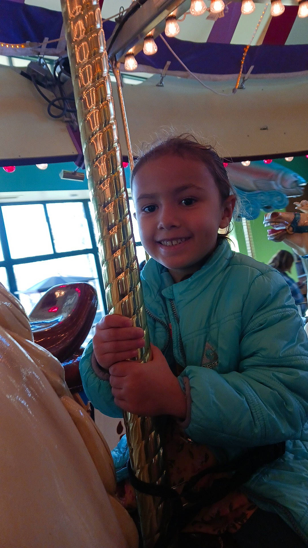 Savannah is registered to the contest to win money with this photo: amusement_park, amusement_ride, carousel, child, event, fair, fun, happy, joy, leisure, musical_instrument, nonbuilding_structure, park, person, plucked_string_instruments, recreation, smile, string_instrument, vacation