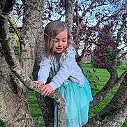 Hailey is registered to the contest to win money with this photo: child, clothing, dress, eveningdress, face, formalwear, grass, head, land, nature, outdoors, park, person, photography, plant, portrait, tree, treetrunk, vegetation, woodland