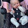 Harper joined the competition — help win amazing prizes! baby, child, infant, car_seat, safety_harness, smile, happy, cute, floral_clothing, onesie, pink, black, pattern, seat, outdoor, person, small_child, hand_in_mouth, head, face