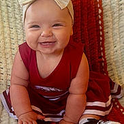 Aubrey is registered to the contest to win money with this photo: baby, infant, smiling, red_dress, headband, bow, shoe, plaque, six_months, milestone, blanket, texture, cute, happy, chubby_cheeks, sitting, hands, feet, indoors, portrait