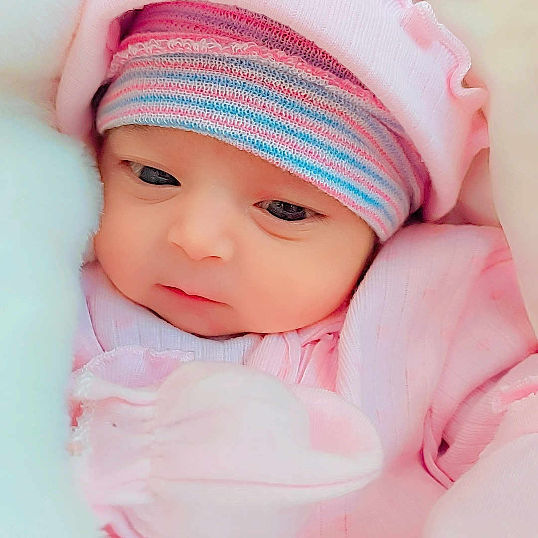 Zirwa is registered to the contest to win money with this photo: baby, blanket, bundle, child, closeup, cozy, cute, eyes, face, hat, infant, newborn, pink_clothing, portrait, resting, sleepwear, soft_texture, striped_hat, warm, young_child
