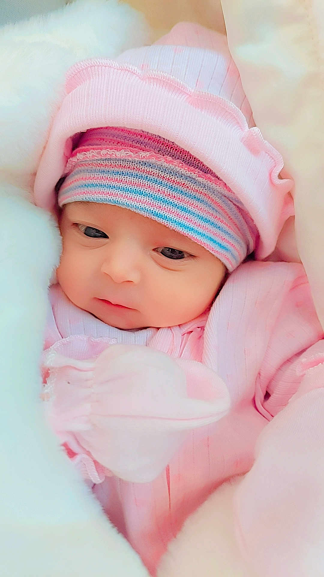 Zirwa is registered to the contest to win money with this photo: baby, newborn, infant, pink_clothing, hat, striped_hat, blanket, soft_texture, cute, face, eyes, sleepwear, cozy, child, portrait, young_child, warm, resting, bundle, closeup