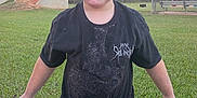 Daniel is registered to the contest to win money with this photo: child, mud, bucket, grass, outdoor, black_shirt, face, dirt, playing, young_boy, short_hair, park, daylight, casual_clothing, fun, nature, person, adventure, summer, activity