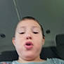 Daniel is registered to the contest to win money with this photo: child, blurry, selfie, face, expression, shirt, cartoon, car_interior, seat, young, person, indoors, casual, colorful, clothing, portrait, head, mouth, kid, seatbelt