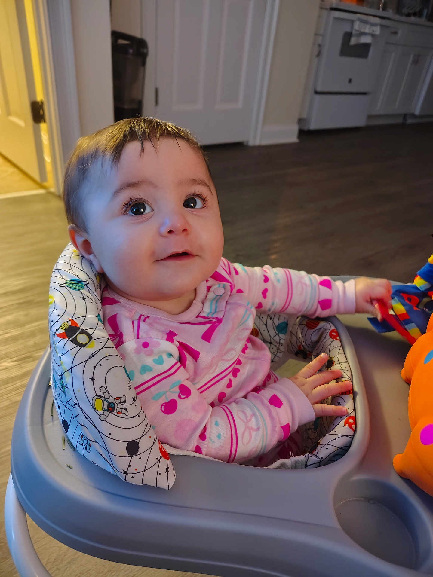 Juniper joined the competition — help win amazing prizes! baby, infant, child, onesie, pink_clothing, walker, toy, kitchen, flooring, curious, indoor, face, hands, sitting, play, childcare, expression, young, person, home