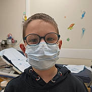 Owen participe au concours pour gagner de l'argent avec cette photo : casual_clothing, child, eyewear, face_mask, glasses, healthcare, hoodie, indoor, jellyfish, medical_room, person, portrait, protection, sea_creatures, seahorse, short_hair, standing, turtle, wall_stickers, young