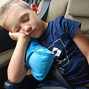 Stephane a rejoint le concours — aidez-le/la à gagner de superbes lots ! blue_shirt, boy, car, casual_clothing, child, closed_eyes, daylight, denim_shorts, indoors, peaceful, pillow, portrait, relaxed, resting, seat, seatbelt, sleeping, travel, window, young