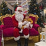 Gina participe au concours pour gagner de l'argent avec cette photo : santa_claus, child, toddler, christmas_tree, ornaments, holiday, festive, shopping_mall, red_suit, white_beard, glasses, gold_decor, purple_couch, curious, indoor, seasonal, gift, decorations, people, seated