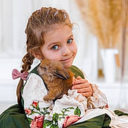 Uliana is registered to the contest to win money with this photo: child, girl, rabbit, pet, animal, cute, smile, braid, glitter, dress, embroidery, green, white, soft, cozy, indoors, portrait, holding, fluffy, adorable