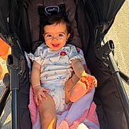 Nalianna is registered to the contest to win money with this photo: baby, stroller, blanket, smiling, happy, infant, child, sunlight, foot, hand, clothing, diaper, pink, white, outdoor, cute, portrait, person, seat, playful