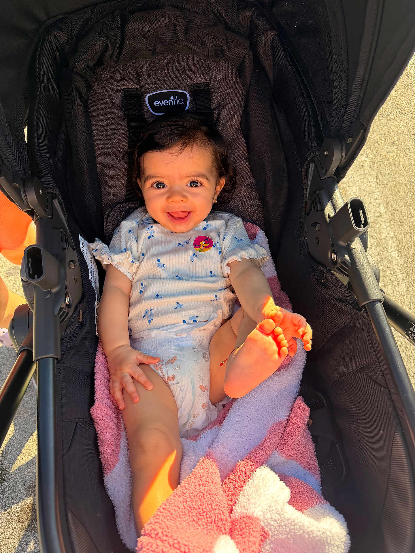 Nalianna is registered to the contest to win money with this photo: baby, stroller, blanket, smiling, happy, infant, child, sunlight, foot, hand, clothing, diaper, pink, white, outdoor, cute, portrait, person, seat, playful