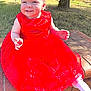 Adalynn is registered to the contest to win money with this photo: baby, child, red_dress, flower_headband, smiling, outdoor, grass, tree, brick, socks, sunlight, happy, portrait, toddler, cute, headband, nature, sitting, daylight, person