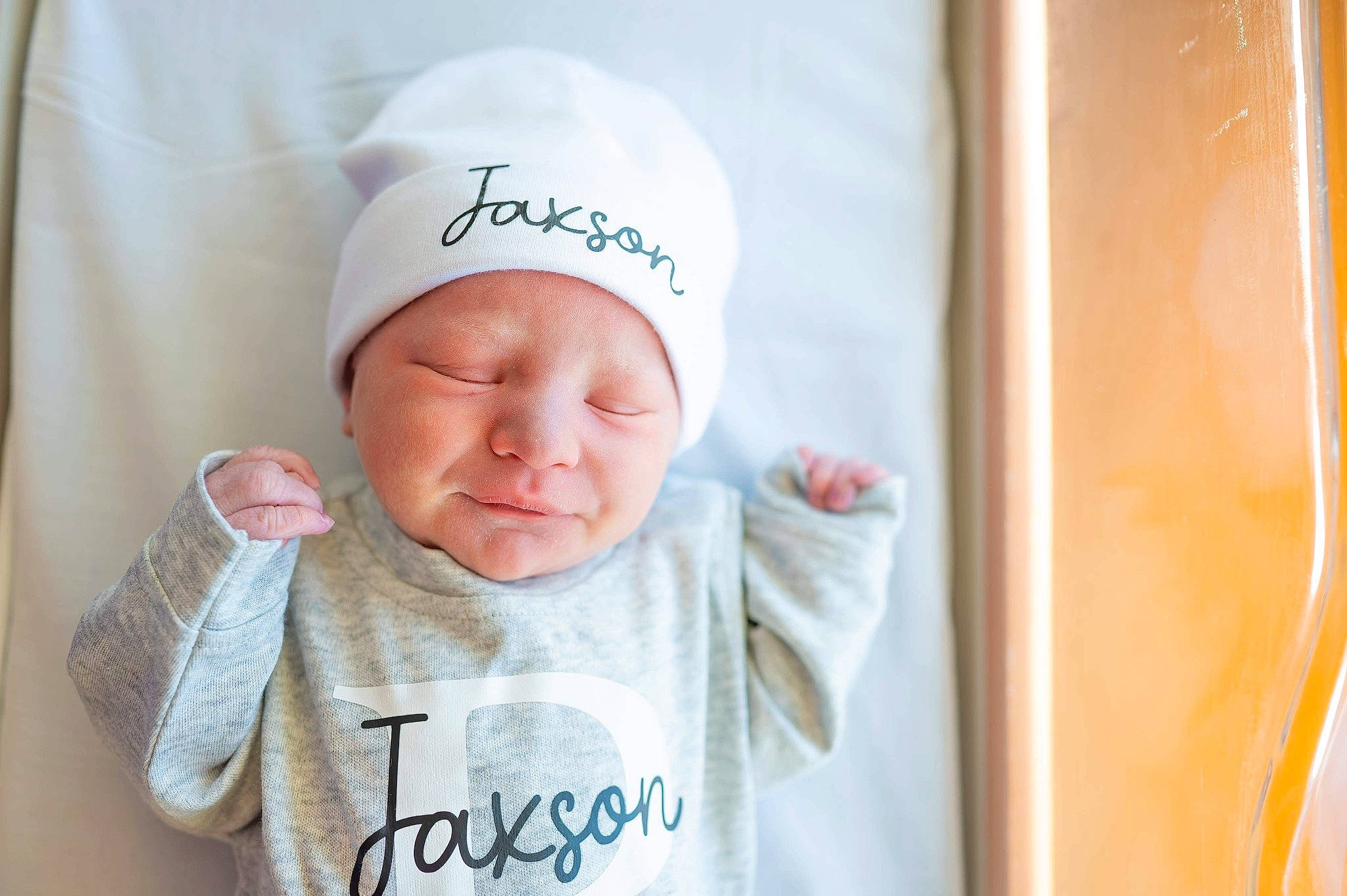 Jaxson is registered to the contest to win money with this photo: baby, baby_sleeping, baby_toddler_clothing, cap, cheek, child, comfort, fashion_accessory, finger, gesture, happy, headgear, headwear, linens, person, product, room, sleeve, t_shirt, textile