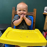 Kolsen joined the competition — help win amazing prizes! baby, blue_chair, child, clapping_hands, face, food, foot, furniture, green_wall, happy, high_chair, home, indoor, messy, person, shirt, smiling, table, wooden_chair, yellow_tray