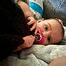 baby, infant, pacifier, blanket, soft_texture, closeup, face, hand, cute, lying_down, comfort, child, sleepy, mickey_mouse, pink, cozy, resting, expression, indoor, portrait