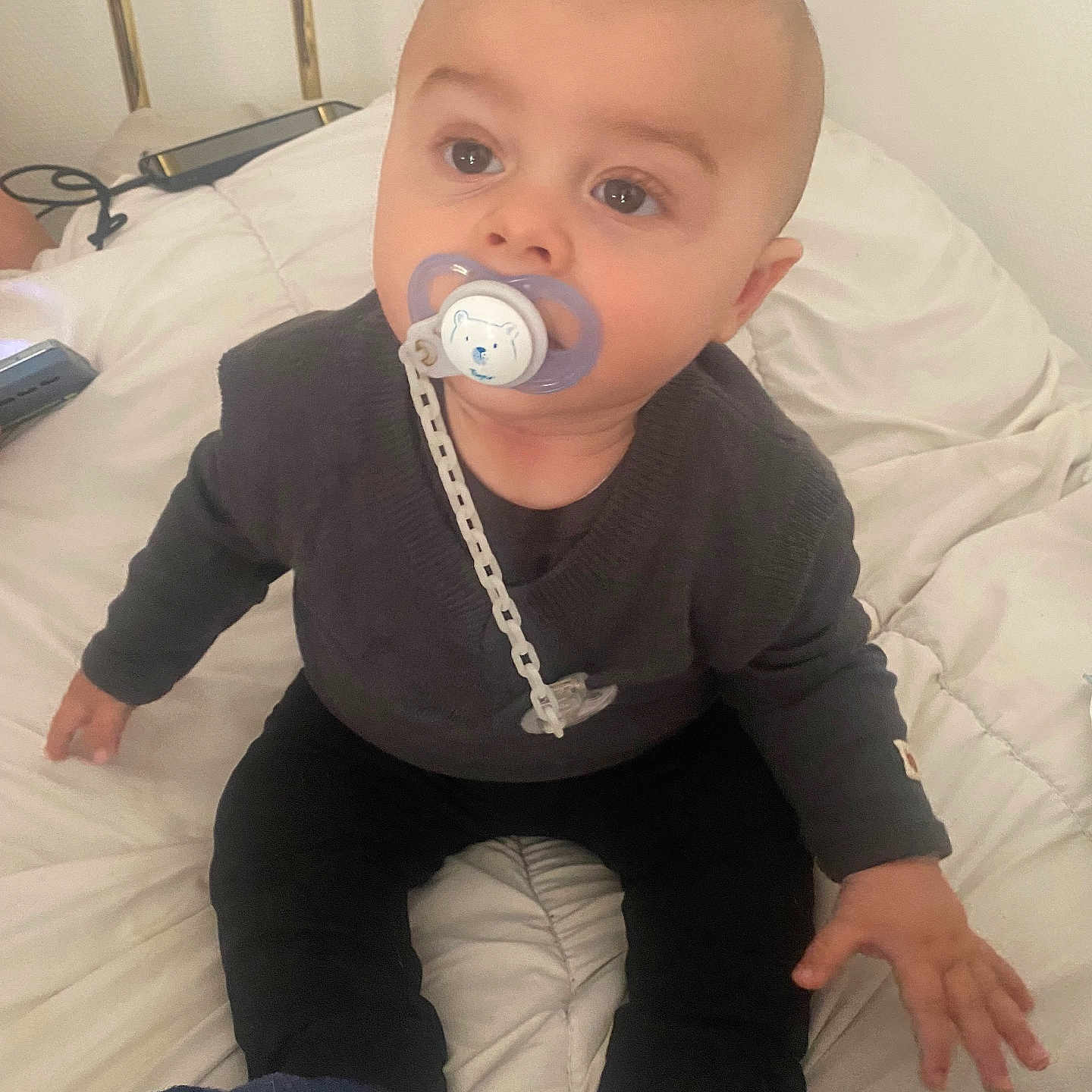 Lyam a rejoint le concours — aidez-le/la à gagner de superbes lots ! baby, bed, blanket, bright_eyes, child, comfort, curious, cute, face, hand, head, indoor, infant, pacifier, person, rest, sitting, socks, sweater, young_child