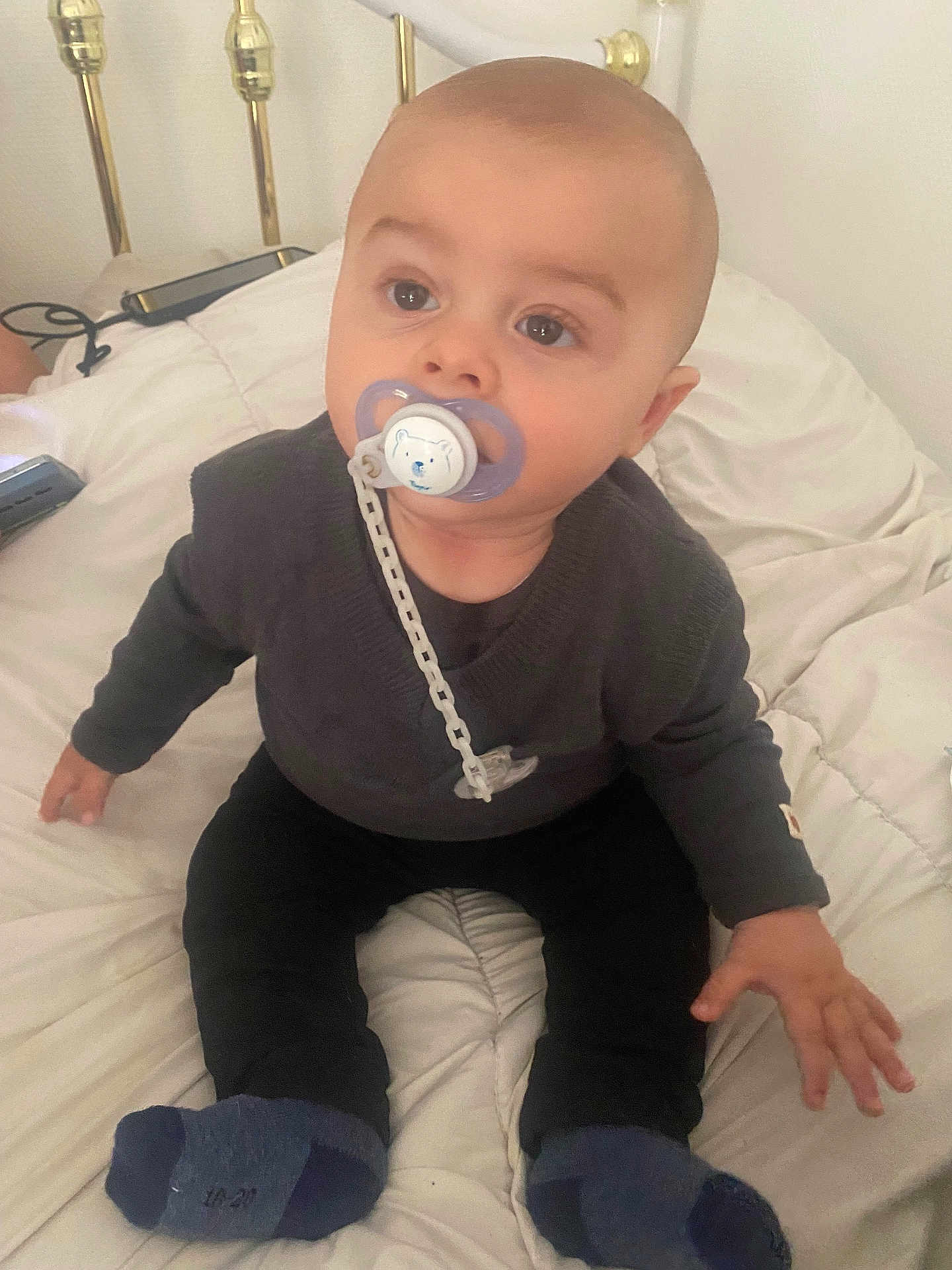 Lyam a rejoint le concours — aidez-le/la à gagner de superbes lots ! baby, pacifier, bed, sitting, socks, sweater, face, child, indoor, blanket, hand, head, cute, infant, person, young_child, comfort, rest, curious, bright_eyes