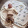 Jules a rejoint le concours — aidez-le/la à gagner de superbes lots ! baby, infant, blanket, numbers, months, wood_floor, clothing, socks, face, person, lying_down, round_blanket, wooden_ring, flooring, indoor, cozy, cute, child, portrait, age_marker