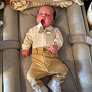 Jules participe au concours pour gagner de l'argent avec cette photo : baby, infant, yawning, bow_tie, pants, white_shoes, changing_mat, towel, baby_clothes, cute, sleepy, newborn, indoor, soft_lighting, comfortable, cozy, baby_accessories, neutral_colors, relaxed, portrait