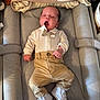 baby, infant, yawning, bow_tie, pants, white_shoes, changing_mat, towel, baby_clothes, cute, sleepy, newborn, indoor, soft_lighting, comfortable, cozy, baby_accessories, neutral_colors, relaxed, portrait