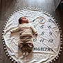 Jules a rejoint le concours — aidez-le/la à gagner de superbes lots ! baby, infant, milestone_blanket, numbers, wooden_ring, flooring, clothing, cream, beige, socks, lying_down, portrait, child, baby_girl, baby_boy, cute, indoors, soft_texture, round_blanket, pompoms