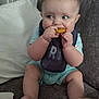 baby, child, sitting, couch, bib, food, nugget, foot, hand, face, indoor, curious, clothing, pillow, box, home, furniture, skin, person, young
